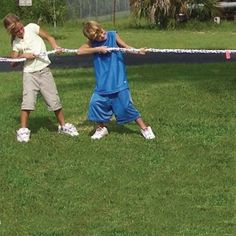 two children playing tug - ball in the yard