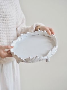 a woman is holding a white plate in her hands