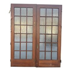 two wooden doors with frosted glass on top and bottom panels, one open to the other side