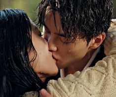 a man and woman kissing in the rain