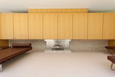 a living room with two couches and a fireplace in the center, surrounded by wooden cabinets