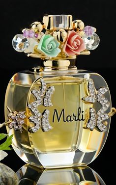 the perfume bottle is decorated with flowers and butterflies on it's top, which reads marli