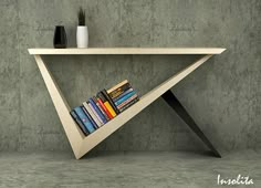 a book shelf with books on it in the shape of a triangle, against a concrete wall