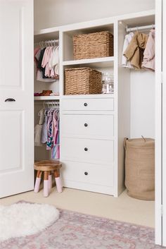 a white closet filled with lots of clothes and other items on shelves next to a rug