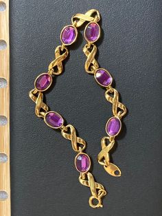 Looking for a stunning vintage bracelet? Check out this AVON gold tone bracelet featuring gorgeous PURPLE amethyst look alike cabochons in an infinity link design.  Perfect for both office wear and dinner parties, it's versatile and stylish. **Details - 8" long x 1/4" wide - Clasp in good working order - Elegant dainty vintage estate jewelry - Well taken care of, no visible damage or discoloration - All fashion gems are securely seated and in good condition - 6 beautiful faux amethyst stones - C Gold Amethyst Bracelets For Formal Occasions, Amethyst Stones, Link Design, Vintage Bracelet, Vintage Avon, Vintage Bracelets, Amethyst Stone, Exquisite Jewelry, Dinner Parties