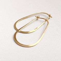 "Modern oval hoops. Handmade and hand formed into an oval loop, then lightly hammered and polished to a soft shine. The rounded elongated shape gives them a casual modern look. This listing is for one pair of either gold filled or recycled sterling silver. You choose your preference. These hoops measure approximately 1 1/8\" long. Please see measurment photo to get a good idea of the size of these earrings. Available in sterling silver,14k Yellow Gold Filled (shown), or 14k Rose Gold filled. Cho Simple Oval Everyday Jewelry, Simple Everyday Oval Jewelry, Modern Hammered Drop Hoop Earrings, Minimalist Hammered Metal Hoop Earrings, Minimalist Handmade Oblong Jewelry, Minimalist Hammered Hoop Earrings For Everyday, Minimalist Oval Hoop Earrings Tarnish Resistant, Minimalist Oval Tarnish Resistant Hoop Earrings, Modern Hand Forged Hoop Earrings