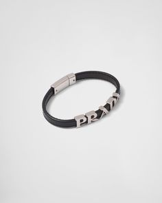 Push-lock clasp Metal lettering logo Modern Black Bracelets With Palladium Hardware, Black Leather Bracelet With Palladium Hardware For Formal, Black Leather Bracelet With Palladium Hardware For Formal Occasions, Designer Black Leather Bracelet, Luxury Leather Bracelets For Business, Black Leather Jewelry With Palladium Hardware, Luxury Black Leather Bracelet With Palladium Hardware, Business Bracelet With Leather Strap, Designer Silver Leather Bracelet With Palladium Hardware