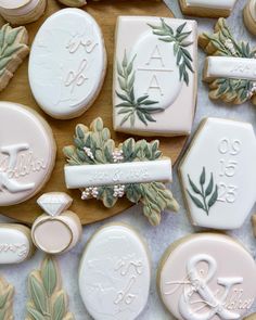 some cookies are laying out on a table with leaves and monogrammed cookie cutters