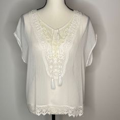 Ariat Sheer White Blouse Short Sleeve Light Weight Polyester Heavy Embroidered Detail At Front Bodice Split Neck Line With Cording Details Lace Trim Detail New - Never Worn Excellent Condition See Photos For Measurements And Details Measurements By Hand, May Vary Slightly Embroidered Lace V-neck Top, Casual White Blouse With Lace Work, White Embroidered Short Sleeve Lace Top, Elegant Floral Embroidery Top For Vacation, Elegant Floral Embroidered Top For Vacation, Short Sleeve Blouse With Crochet Trim For Vacation, Bohemian Short Sleeve Blouse With Lace Work, White Lace Vacation Tops, Beach Lace Blouse With Floral Embroidery