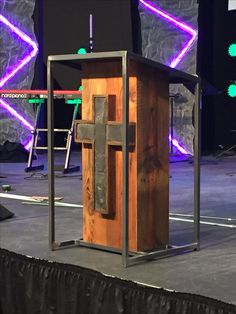 a wooden podium with a cross on it at a convention or conference room stage set up