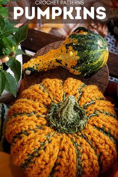 crochet pumpkins are sitting on a wooden board