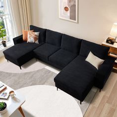 a living room with a black couch and white rug