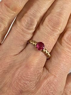 Welcome to paradise. This beauyiful ruby solitare is set in an antique 14k gold prong setting that secures it in the most lovrky way. The ting feels feminine, sturdy and elegant.  Ruby: Authentic pink/fuscia in color. Gold Precious metal: 14K  Setting : Antique , Ripple , antique prong setting  style  Ring Size 8.75 Excellent preowned condition  Free Shipping with tracking right to your door Classic Ruby Ring With Diamond Cut, Formal Solitaire Ruby Ring With Round Stone, Classic Ruby Solitaire Rings, Ruby Ring With Diamond Cut Round Band, Ruby Ring With Diamond Cut, Classic Lab-created Ruby Ring With Diamond Cut, Classic Ruby Solitaire Birthstone Ring, Classic Solitaire Ruby Birthstone Ring, Ruby Solitaire Ring With Round Stone For Wedding