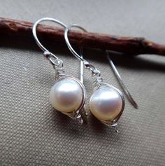 Single freshwater pearls are wrapped with sterling silver wire in a herringbone frame. These round, white pearls drop from sterling silver ball end ear wires. These pearls have a smooth nacre and excellent luster. Classic pearl earrings with a modern look! (The red smudges on the Pearl Jewelery, Wire Wrapped Pearl, Classic Pearl Earrings, White Pearl Earrings, White Pearl Earring, Sterling Silver Wire Wrap, Coin Pearls, Earrings White, June Birth Stone