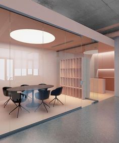 an empty conference room with glass walls and round table surrounded by chairs in the center