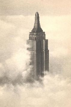 the empire building towering above the clouds in new york city