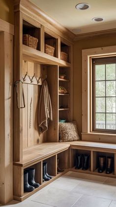 a mud room with wooden shelves and shoes on the floor, next to a window