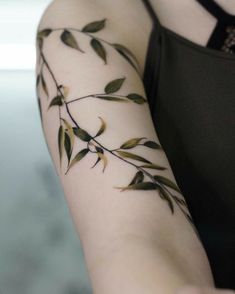 a woman's arm with leaves on it