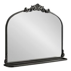 a large mirror with an ornate design on the top and bottom frame, in black