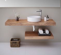 a bathroom with two wooden shelves and a white bowl on the counter top next to a sink