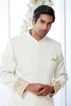 This ivory sherwani set features kiran dori embroidery on the cuffs and a stepper collar detail on a matka silk base. This ensemble is paired with a cotton silk kurta and a stretchable cotton silk trouser. Complimenting footwear is also available.From Seema Gujral's Tuscan Summer collection. DELIVERY TIMEPlease allow 8-12 weeks for your outfit to arrive.FABRIC DETAILSMatka SilkProfessional cleaning only. Elegant Raw Silk Bandhgala With Naqshi, Elegant Bandhgala With Naqshi In Raw Silk, Formal Off White Set With Traditional Drape, Formal Off White Sets With Traditional Drape, Cream Sherwani With Chikankari Embroidery And Long Sleeves, Cream Long Sleeve Sherwani With Chikankari Embroidery, Cream Nehru Jacket With Resham Embroidery Long Sleeve, Elegant White Bandhgala Straight Kurta, Elegant Cream Bandhgala With Chikankari Embroidery