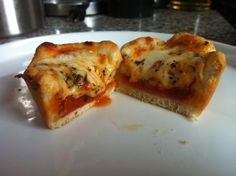 two pieces of pizza sitting on top of a white plate next to a silver pot