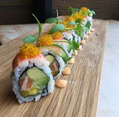 sushi rolls are lined up on a wooden board