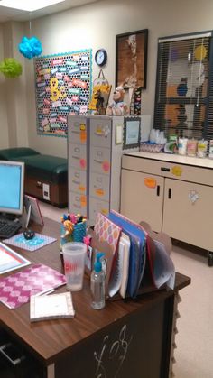 an office with two computers on the desk and several other items in front of it