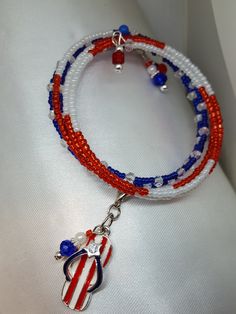 "Patriotic jewelry/Red White Blue Bracelet/Charm bracelet/ USA Jewelry This memory wire bracelet combines red, white, and blue glass beads. The darling flip flop enamel charm with Stripes and a rhinestone make it a perfect summer fit. The style is right for many patriotic occasions. The design was carefully planned to create a pleasing lay-out of the beads on your wrist. The bracelet shows like five bracelets in one in that there are five different patterns successively. It measures 36\" inches Patriotic Adjustable Dangle Jewelry, Lay Out, Patriotic Jewelry, Usa Jewelry, Memory Wire Bracelet, Memory Wire Bracelets, Bracelet Charm, Memory Wire, Wire Bracelet