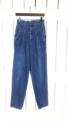 Vintage Ronica high waisted pleated tapered leg blue denim jeans/double side seam pleated jeans/waist 27" Measurements...taken flat      -across waist: 13.5"      -across hips: 17.5"      -inseam: 34"      -front rise: 13"      -marked size: vintage 10 (see measurements) Features... -super high 13" rise -the perfect medium blue wash -pleated hip with pockets -cool double seam down each leg -cool seam detail on front - tapered leg -100% cotton-no stretch -Ronica Condition:  -excellent vintage con Classic High Waist Medium Wash Pants, Classic Medium Wash High Waist Pants, High Waist Mom Fit Jeans With Pockets, High Waist Mom Fit Bottoms With Pockets, High Waist Mom Jeans For Work, High Waist Mom Fit Denim Blue Bottoms, High Waist Mom Fit Denim Bottoms, High Waist Mom Fit Jeans With Belt Loops, High Waist Mom Jeans With Belt Loops