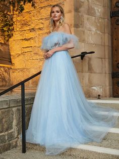 a woman in a blue dress standing on steps