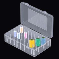 an open plastic case filled with spools of thread and needle tip holders on black background