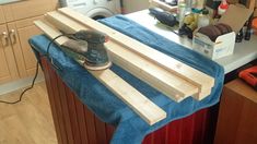 a cordless sanding machine sitting on top of a blue towel in a kitchen