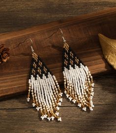 These handmade beaded earrings are a stunning accessory that seamlessly blends elegance with a touch of bohemian flair. Harmonious combination of black, yellow, and gold hues. These colors work together to create a striking contrast and an air of sophistication. The intricate craftsmanship and attention to detail make them a unique and eye-catching addition to any outfit. Approx 4 in.long Bohemian Black Tassel Earrings With Round Beads, Black Bohemian Tassel Earrings With Round Beads, Black Tassel Drop Earrings With Colorful Beads, Black Bohemian Beaded Earrings With Gold Beads, Bohemian Black Tassel Earrings With Dangling Beads, Black Beaded Bohemian Tassel Earrings, Bohemian Black Chandelier Earrings With Colorful Beads, Handmade Beaded Earrings, Handmade Earrings Beaded