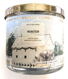 a glass jar with an image of a white barn on it's side and the words winter written in gold