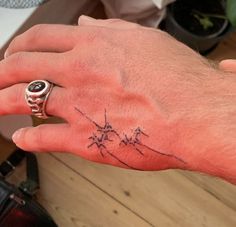 a man's hand with a small tattoo on his left wrist and an arrow in the middle