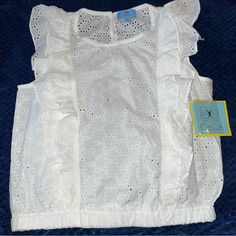 Adorable Ruffled Eyelet Sleeveless Top By Cece Brand-New With Tags In Ivory-Size Extra Small. Two Ruffles On Each Side On The Front And The Back-Elasticised Waist- One Button Closure - 100% Cotton Approximate Measurements:Iunderarm To Underarm 18”-Elastic Band Around The Bottom Across 15 Inches But Stretches-Length 19.5”-Machine, Washable, Cold (In The Description. The Only Colour Would Let Me Put Was White Or Cream, And It’s Ivory, Which Is Off White -It Doesn’t Look As White As The Pictures, B Fitted Sleeveless Lace Top With Ruffles, Chic Tops With Lace Trim And Ruffled Straps, Chic Ruffled Lace Top For Summer, Spring Sleeveless Lace Top With Ruffles, Cute Ruffled Tank Top For Spring, Summer Sleeveless Lace Top With Ruffles, White Cotton Tops With Ruffled Straps, Sleeveless Ruffled Lace Top For Spring, Casual Fitted Lace Top With Ruffles