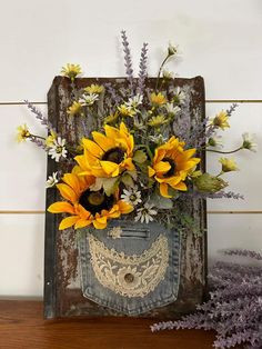 a bouquet of sunflowers and other flowers in an old suitcase