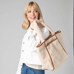 Add a touch of elegance to your daily look with the Toasty Tote. Crafted from luxurious cream-hued faux shearling, the bag features an eye-catching contrast with its faux suede binding and bottom panel. Secure your belongings with a zip pocket and snap button closure details. Carry your essentials in style with this must-have luxury piece. Features: Color: CreamMaterials: 100% PolyesterSize: 19" wide, 13" tall, 7" deepHandle: 10" Drop Cream Shoulder Bag For Winter Travel, Winter Travel Cream Shoulder Bag, Chic Everyday Shoulder Bag With Plush Lining, Everyday Double Handle Shoulder Bag With Faux Fur Lining, Chic Everyday Shoulder Bag With Faux Fur Lining, Winter Shoulder Bag With Plush Lining For Everyday Use, Everyday Tote Shoulder Bag With Faux Fur Lining, Everyday Fall Bag With Plush Lining, Fall Bag With Plush Lining