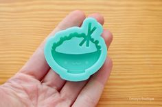 a hand holding a green rubber stamp with a bowl on it