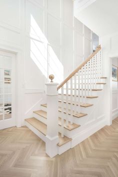 an image of a white staircase in a house with wood flooring and hardwood floors