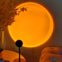 a living room with a round light on the wall next to a couch and table