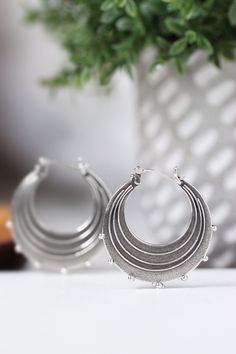 "Evocative of raindrops striking a pool of water, circles radiating outward from the point of impact and smaller droplets becoming airborne. These earrings are made completely of sterling silver, right down to the ear wires which are hinged and connect in a catch on the other side. The line and ball design is repeated on both sides of each earring. Each hoop measures approximately 1.25\" in diameter. The hoops have been given a patina to darken them and then tumbled in steel shot to give them a Nickel-free Metal Drop Hoop Earrings, Metal Drop Hoop Earrings With Ear Wire, Silver Hoop Chandelier Earrings, Raindrop Earrings, Earrings Silver Hoops, Ball Design, Earrings Round, Sterling Silver Hoop Earrings, Sterling Silver Hoops