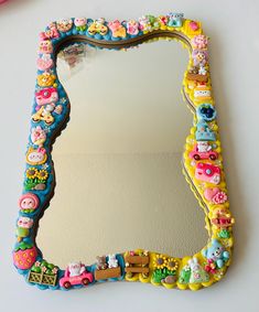 a decorative mirror is sitting on the wall next to a pink toothbrush and scissors