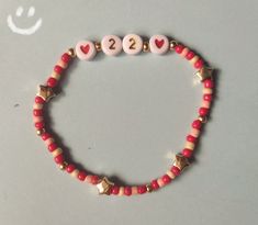 a red beaded bracelet with two hearts and one star on it, which reads 22