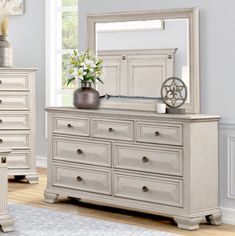 a white dresser and mirror in a room