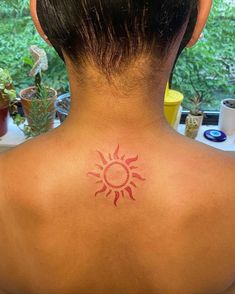 a woman with a sun tattoo on her back