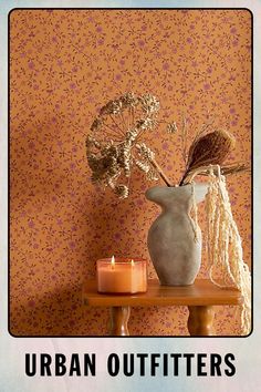 an image of a vase with flowers in it on a table next to a candle