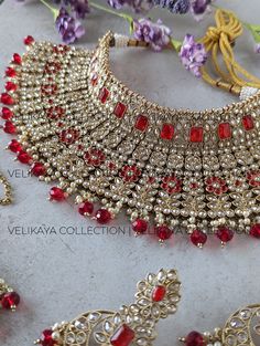 This Jodha style ruby red semi-bridal set consists of a statement necklace, earrings and tikka. Necklace plating is antique gold. Sparkling champagne stones with superior craftsmanship. Perfect for Indian and Pakistani weddings. Product Details: * Necklace -  Comes with adjustable zari cord.  * Earrings - For pierced ears. Length: 7 cm, Width: 4 cm, Weight: 19 gm approx * Maang Tikka Buy bridal bangles, chuda / choora and kalira here: https://www.etsy.com/shop/VelikayaCollection?section_id=30852312 Check out our collection of nose-rings, pasa, haathphool and hair accessories: https://www.etsy.com/ca/shop/VelikayaCollection ----------- CARE ----------- - Store in air tight zip lock bags - Do not expose to moisture/water - Do not spray chemicals or perfumes on the jewelry Please feel free to Heavy Red Lehenga For Diwali, Heavy Red Lehenga For Reception, Festive Heavy Red Lehenga, Red Heavy Lehenga For Wedding, Heavy Red Wedding Sets, Red Ruby Bridal Necklace For Reception, Red Meenakari Jewelry For Reception, Traditional Red Jewelry For Reception, Red Chandbali Earrings With Zari Work