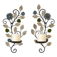 two metal wall sconces with candles and leaves on them, one holding a candle